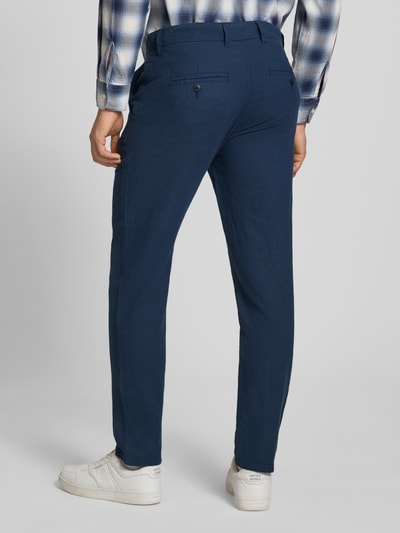 Mannenmodel draagt Tapered Fit Hose met steekzakken model 'STACE' van Jack & Jones in donkerblauw, materiaal-mix met katoen, geheel zicht van achter.