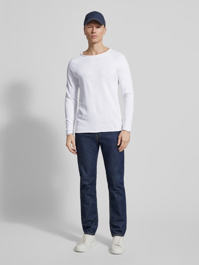 Männermodel trägt Longsleeve mit Rollsaum Modell 'SONOMA' von American Vintage aus weißer Baumwolle, gerader Schnitt, Ganzkörperansicht von vorne.
