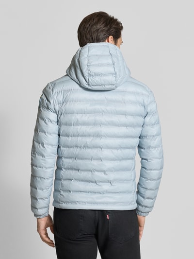 Männermodel trägt Steppjacke mit Zweiwege-Reißverschluss Modell 'Charles' von Blauer Usa in Hellblau, Regular Fit, Kapuze, Label-Detail, Ganzkörperansicht Rückansicht. Rückenlänge 65 cm, Schulterbreite 47 cm, Brustweite 55 cm, Ärmellänge 65 cm.
