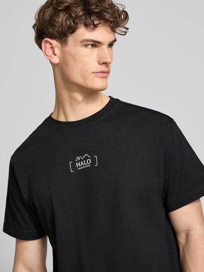 Männermodel trägt T-Shirt mit Label-Print von HALO in Schwarz, reine Baumwolle, Regular Fit, Rundhalsausschnitt, Nahaufnahme Oberkörper.