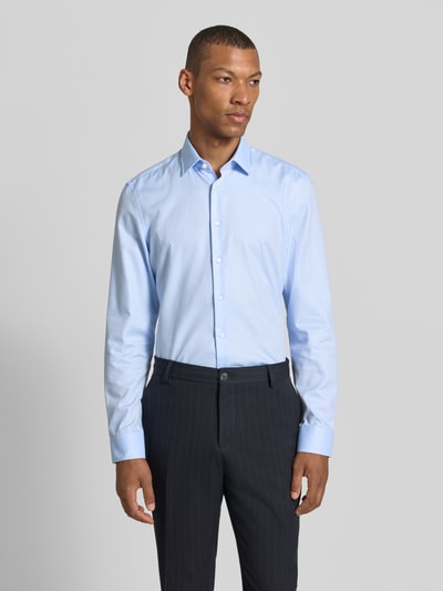 Männermodel trägt Super Slim Fit Business-Hemd mit Kentkragen von Jake*s in Hellblau aus Reine Baumwolle mit Knopfleiste, Sportmanschetten und abgerundetem Saum, Rückenlänge 79 cm, Schulterbreite 46 cm, Ärmellänge 66 cm, Ganzkörperansicht von vorne.