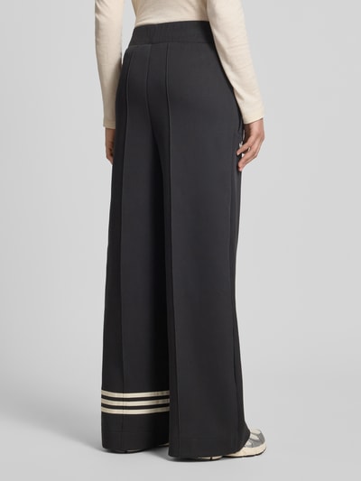 Frauenmodel trägt Wide Leg Sweatpants aus Baumwoll-Mix Modell 'NEUCL' von adidas Originals, Optik: Unifarben, Passform: Wide Leg, Logo-Stitching, Kontraststreifen, Bundabschluss elastisch mit Tunnelzug und Weitenregulierung, Reißverschlusstaschen, Materialverarbeitung: Sweat, Ganzkörperansicht Rückansicht.