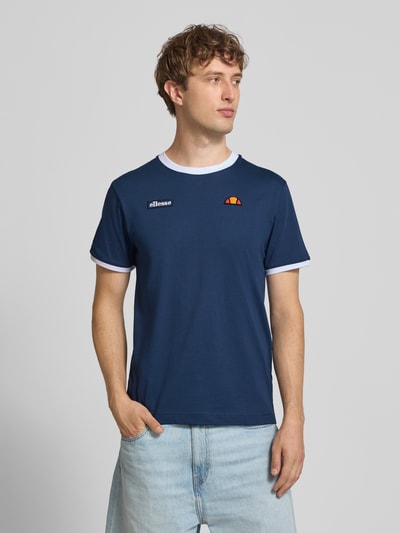 Männermodel trägt ellesse T-shirt im Retro-Look Modell 'RINGETTO', puur katoen, regular fit, ronde hals, labelstitching, ganzkörperansicht von vorne.