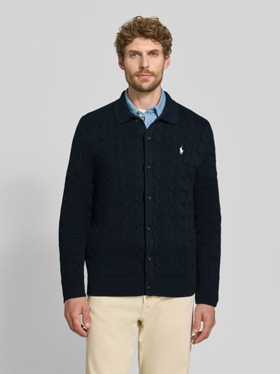 Männermodel trägt Regular Fit Strickjacke aus reiner Baumwolle von Polo Ralph Lauren, dunkelblau, grobe Strickstruktur, Ganzkörperansicht von vorne. Kontext: Herren Poloshirt von Polo Ralph Lauren