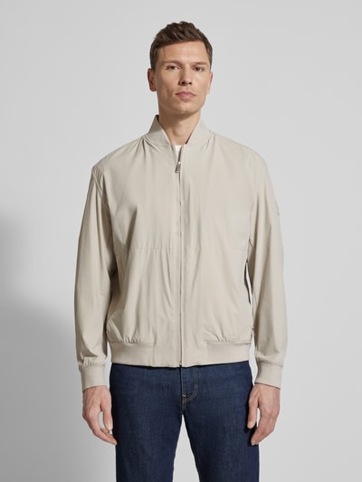 Männermodel trägt Regular Fit Blouson mit Baseball-Kragen Modell 'OSURF' von BOSS Orange in Beige, unifarben, Ganzkörperansicht von vorne.