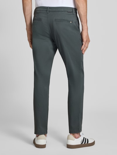 Mężczyna nosi chinosy Chino mit Eingrifftaschen Modell 'MARCO' od JACK & JONES w odcieniu grafitowym, wpuszczane i tylne kieszenie, krój straight fit, zapięcie na guzik i zamek błyskawiczny, Szerokość w rozmiarze 32/32: 42 cm, Długość wewnętrzna nogawki w rozmiarze 32/32: 77 cm, zdjęcie całej sylwetki z tyłu.