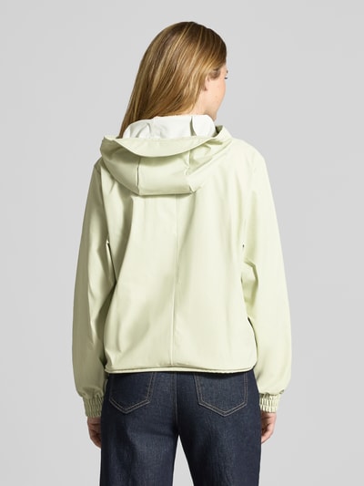 Modelka prezentuje Kurtkę 'Jacke mit Abdeckleiste' od Rains, prosty krój, kaptur z tunelem, elastyczne zakończenia rękawów, długość tyłu w rozmiarze S: 58 cm, szerokość ramion w rozmiarze S: 43 cm, szerokość klatki piersiowej w rozmiarze S: 55 cm, długość rękawów w rozmiarze S: 63 cm, jasny kolor, gładka faktura, widok całej sylwetki z tyłu.