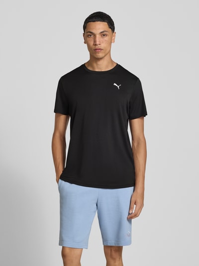Männermodel trägt Regular Fit Sport-T-Shirt mit Logo-Print Modell 'TAD Essential' von PUMA, schwarze Farbe, Ganzkörperansicht von vorne, Herren Sport-T-Shirt von PUMA Performance.
