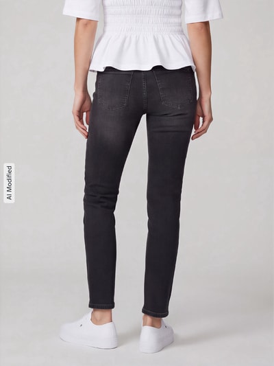 Frauenmodel trägt Straight Fit Jeans aus Baumwoll-Mix Modell 'Dream Cropped' von MAC in dunklem Grau mit weißen Sneakern, Damen Straight Fit Jeans von MAC, Ganzkörperansicht Rückansicht, KI-modifiziertes Bild.