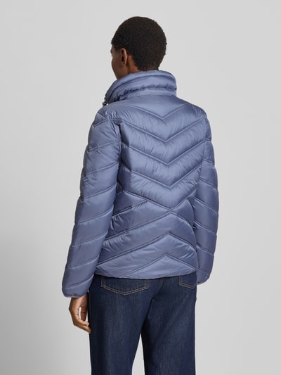Vrouwenmodel draagt Steppjacke mit Stehkragen und Reißverschlusstaschen van Christian Berg Woman Selection in blauw met gewatteerde textuur, regular fit, opstaande kraag, ritssluiting, ritszakken, ruglengte maat 36: 61 cm, schouderbreedte: 42 cm, borstwijdte: 51 cm, mouwlengte: 58 cm, volledig lichaam achteraanzicht.