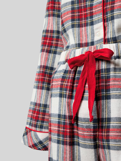 Kobiecy model nosi Relaxed Fit Pyjama-Set aus reiner Bio-Baumwolle Modell 'Helga' od CCDK Copenhagen, kratka, czerwone akcenty, detal pasa, zbliżenie talii.