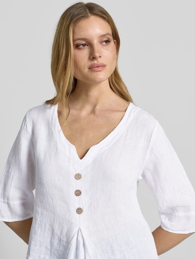 Modelka nosi Regular Fit Bluzę z 3/4 rękawem model 'Ol44iviaa' od ZABAIONE, biały len, dekolt V, zapięcie na guziki, krój regular fit, zbliżenie na górną część ciała.