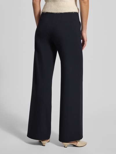 Frauenmodel trägt Stoffhose mit französischen Eingrifftaschen Modell 'NALEY' von SEDUCTIVE, Viskose-Mix, lockerer Schnitt, Ganzkörperansicht Rückansicht.