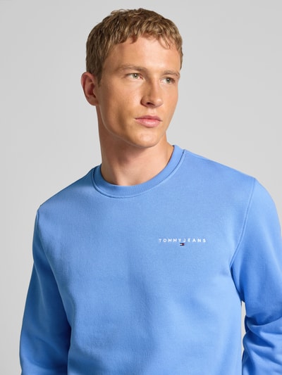 Männermodel trägt Regular Fit Sweatshirt aus Baumwoll-Mix von Tommy Jeans, Optik: Unifarben, Label-Stitching-Applikation, Rundhals, Langarm, gerippt, Materialverarbeitung: Sweat, Nahaufnahme Oberkörper.