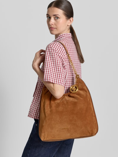 Frauenmodel trägt Handtasche aus Leder mit Label-Applikation Modell 'INDIE' von MICHAEL Michael Kors in Cognacbraun mit Tragehenkel, Hauptfach mit Magnetverschluss, Größe 1 Breite 37 cm, Länge 37 cm, Tiefe 14 cm, Länge Schulterriemen 60 cm; Ganzkörperansicht Rückansicht.