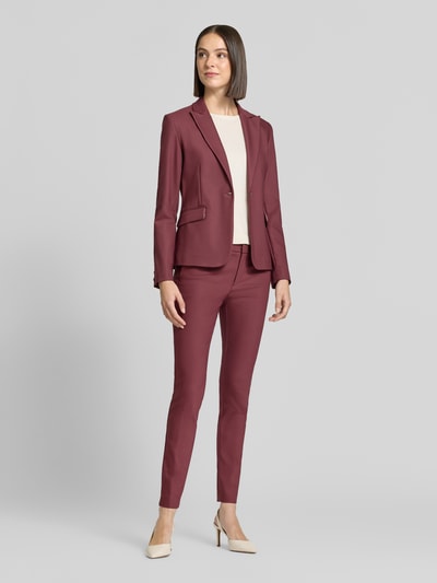 Vrouwenmodel draagt Slim Fit pantalon uit katoenmix van MOS MOSH in bordeauxrood, met knoop- en ritssluiting, riemlussen, bandwijdte 39 cm, binnenbeenlengte 76 cm, gestileerde achterzakken, mix van katoen en elastaan, slim fit, volledige lichaamsaanzicht van voren.