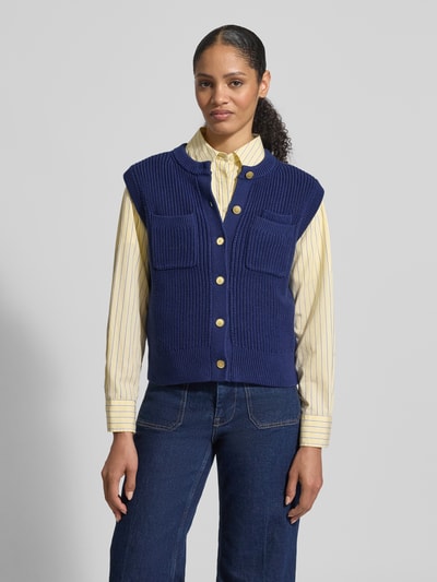 Frauenmodel trägt Regular Fit Strickweste aus reiner Baumwolle von Tommy Hilfiger, Optik: Unifarben, Logo-Applikation, Strick, Ganzkörperansicht von vorne.