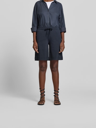 Frauenmodel trägt Shorts mit Modal-Anteil von Juvia in Dunkelblau, Regular-Fit mit Eingrifftaschen, elastischem Bund und Tunnelzug, Baumwoll-Modal-Mix, Ganzkörperansicht von vorne.