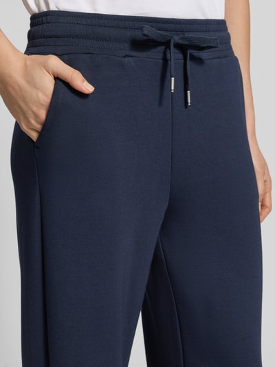 Vrouwenmodel draagt Sweatpants met elastische band Model 'Banu' van Soyaconcept, donkerblauw, materiaalmix met modal, steekzakken, tunnelkoord, los model, detailopname heup en band.