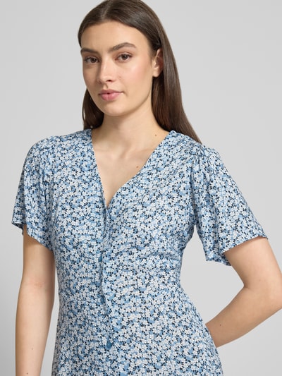 Frauenmodel trägt Minikleid aus reiner Viskose Modell 'EVIDA' von Only mit blauem Allover-Muster, tailliert, Nahaufnahme Oberkörper.