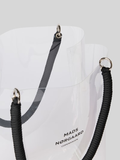 Produktfoto, Handtasche in transparentem Design Modell 'Craze Vinnie' von MADS NØRGAARD mit Tragehenkel in Strukturmuster, Logo-Print, offenes Hauptfach, Maße Breite 29 cm, Länge 37 cm, Tiefe 15 cm, Schulterriemen 55 cm.