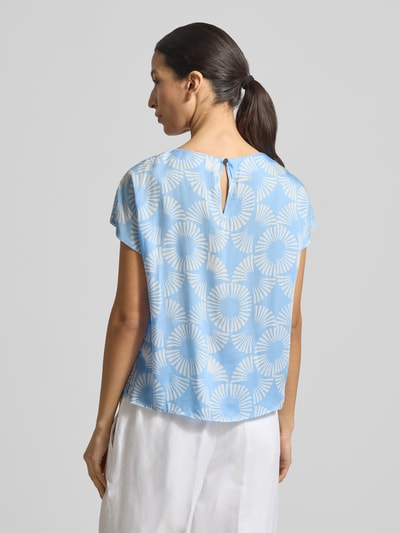 Frauenmodel trägt Blusenshirt aus Viskose mit Rundhalsausschnitt von More & More, hellblau mit weißem Allover-Look, Ganzkörperansicht Rückansicht.