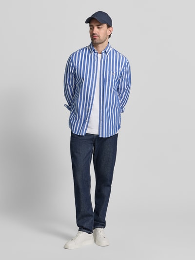Mannelijk model draagt Slim Fit Freizeithemd mit Brusttasche van Gant, witte en blauwe verticale strepen, katoenen stof, slim fit, borstzak, lang met knoopsluiting, casual look, logo-stiksel, volledige lichaamsaanzicht van voren.