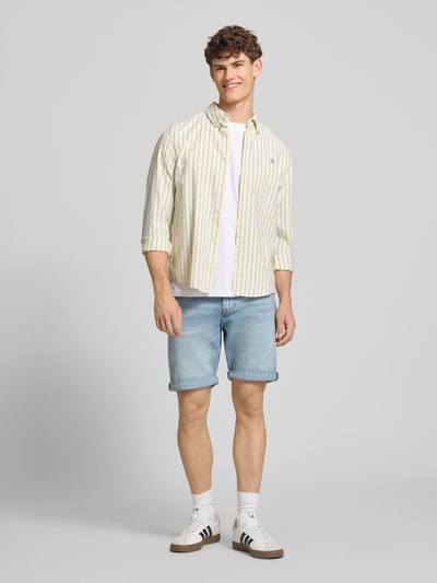 Männermodel trägt Slim Fit Jeansshorts aus Baumwoll-Mix Modell 'ABNER' von Calvin Klein Jeans mit Denim-Optik, Label-Patch, 5-Pocket-Design, hellblaue Farbe, Knopf und verdecktem Reißverschluss, Ganzkörperansicht von vorne.
