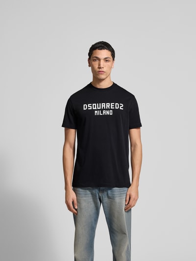 Männermodel trägt Cool Fit T-Shirt aus reiner Baumwolle von Dsquared2, schwarz mit Statement-Print, semitransparent, Rundhalsausschnitt, Ganzkörperansicht von vorne.