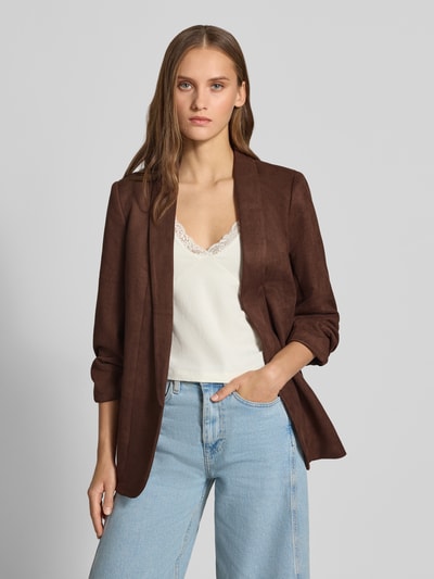Frauenmodel trägt Regular Fit Longblazer mit 3/4-Arm Modell 'BOSELLA' von PIECES in Dunkelbraun, kombiniert mit cremefarbenem Top und hellblauer Jeans, glatte Textur, Ganzkörperansicht von vorne.