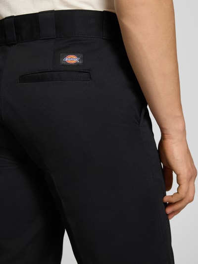 Männermodel trägt Bermudas mit französischen Eingrifftaschen von Dickies aus schwarzer, reiner Baumwolle, Straight Fit, Nahaufnahme Rückansicht.