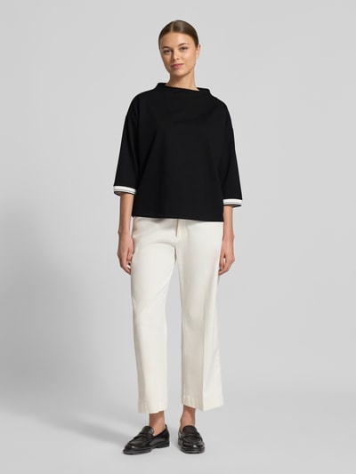 Frauenmodel trägt Relaxed Fit Pullover mit Viskose-Anteil Modell 'Utalba' von Someday, schwarz mit Stehkragen, Ganzkörperansicht von vorne.