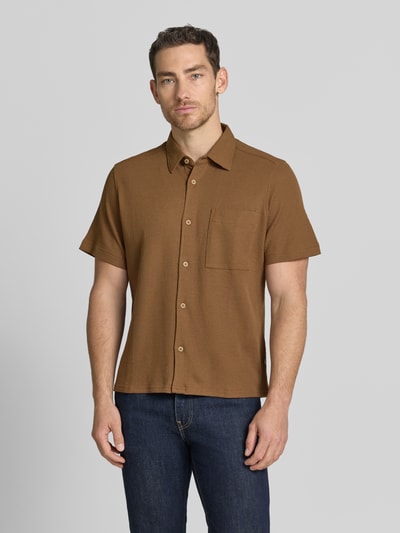 Männermodel trägt Regular Fit Freizeithemd aus Baumwoll-Mix von s.Oliver RED LABEL in Braun, kurzarm, Waffelstruktur, Ganzkörperansicht von vorne.