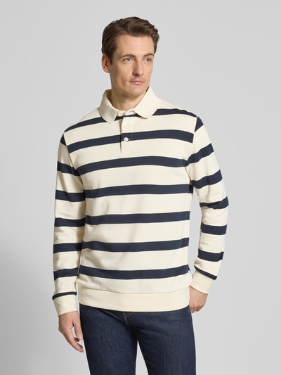 Männermodel trägt Relaxed Fit Poloshirt mit Streifenmuster von Lindbergh, Baumwoll-Mix, Polokragen, creme und navy, Ganzkörperansicht von vorne.