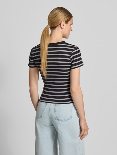 Frauenmodel trägt Slim Fit T-Shirt in Ripp-Optik Modell 'Koale' von Drykorn, schwarz-grau gestreift, reine Baumwolle, Ganzkörperansicht Rückansicht