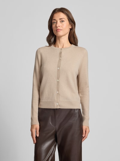 Vrouwenmodel draagt Strickjacke aus reinem Kaschmir mit durchgängiger Knopfleiste van Christian Berg Woman in beige, regular fit, ribgebreide boorden, lange mouwen, volledige knoopsluiting, voorkant, context: damesvest van puur kasjmier, ruglengte maat S 55 cm, mouwlengte 63 cm, detailopname bovenlichaam.