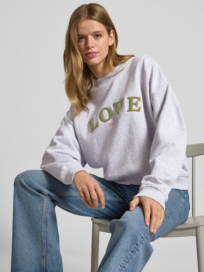 Frauenmodel trägt Sweatshirt mit Statement-Stitching und Rundhalsausschnitt von OH APRIL, Reine Baumwolle, Regular-Fit, Nahaufnahme Oberkörper.