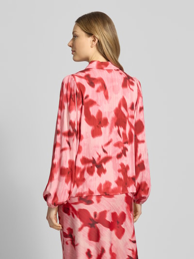 Frauenmodel trägt Regular Fit Hemdbluse aus reiner Viskose Modell 'Asina' von YAS mit floraler Allover-Print, Langärmelig, elastische Ärmelabschlüsse, Hemdblusenkragen, Farbkombination aus Hellrosa und Rot, weiche Textur, Rückenlänge bei Größe 36: 58 cm, Ganzkörperansicht Rückansicht.