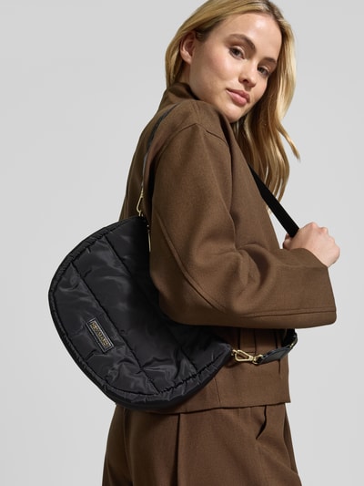 Kobiece model prezentuje Shoulder Bag in Stepp-Optik Modell 'Buddy' od Hey Marly, czarna, detal z logo, odpinany pasek na ramię, Główna przegroda z zamkiem błyskawicznym, Szerokość w rozmiarze 1: 28 cm, Długość w rozmiarze 1: 21 cm, Głębokość w rozmiarze 1: 8 cm, długość paska na ramię w rozmiarze 1: 71 cm, z efektem pikowania, cała sylwetka z przodu.