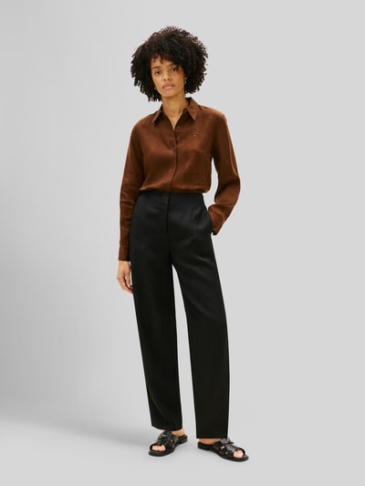 Frauenmodel trägt Relaxed Fit Langarmbluse aus reinem Leinen von Tommy Hilfiger, Optik: Unifarben, Passform: Relaxed-Fit, Hemdkragen, Logo-Stitching, Verschluss: Knopfleiste, Ärmelform: Langarm, Ärmelabschluss: Manschette, Rumpfabschluss: abgerundet, Materialverarbeitung: Flammgarn, Material: Leinen, dunkelbraune Farbe, glatte Textur, Ganzkörperansicht von vorne.