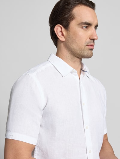 Männermodel trägt Casual Fit Freizeithemd aus Leinen von OLYMP Level Five, reines Leinen, kentkraag, witte knopen, zijaanzicht, Nahaufnahme Oberkörper.