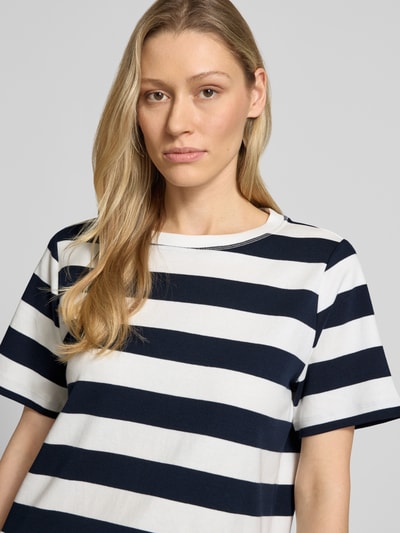 Frauenmodel trägt Relaxed Fit T-Shirt aus reiner Baumwolle von Tom Tailor, Optik: Unifarben, Motiv-Print, Rundhals, Kurzarm, Nahaufnahme Oberkörper.