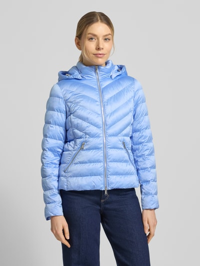 Frauenmodel trägt taillierte Steppjacke mit Zweiwege-Reißverschluss Modell 'ANYA' von Beaumont Amsterdam in Hellblau, Ganzkörperansicht von vorne. Damen Steppjacke mit Kapuze, strukturierte Oberfläche, sichtbare Nähte, glatte Textur, sportlicher Look.
