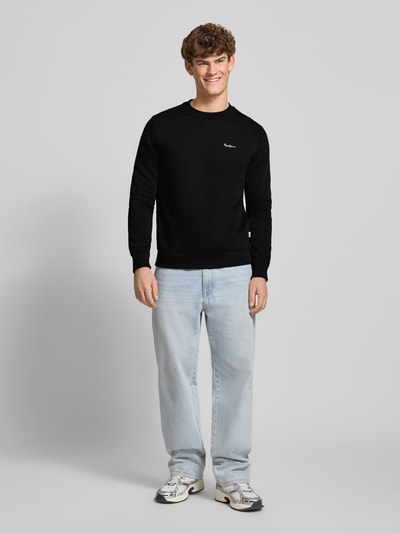 Männermodel trägt Regular Fit Sweatshirt aus Baumwoll-Mix Modell 'GRIFFIN' von Pepe Jeans in Schwarz, Optik: Unifarben, Label-Stitching-Applikation, Rundhals, Langarm, gerippter Abschluss, Sweat-Material. Ganzkörperansicht von vorne.