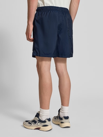 Männermodel trägt navyfarbene Shorts mit Label-Stitching und elastischem Bund von Nike, Regular-Fit, Tunnelzug, Ganzkörperansicht Rückansicht.