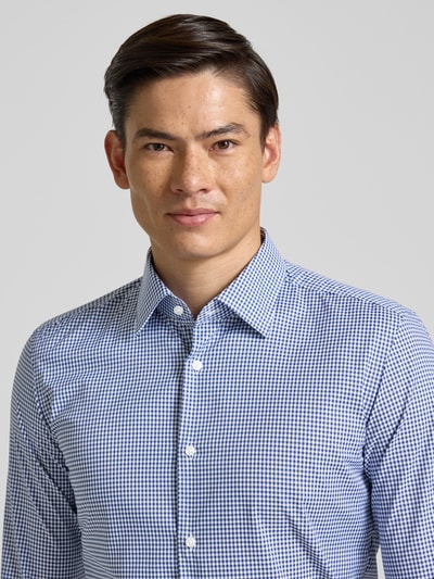 Männermodel trägt Slim Fit Businesshemd mit Kentkragen Modell 'P-HANK-K-261' von BOSS, mehrfarbiges Gitterkaro, Popeline, Nahaufnahme Oberkörper.