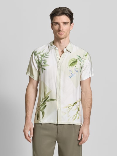 Männermodel trägt Regular Fit Freizeithemd aus Viskose von Guess mit Kentkragen und Knopfleiste in Weiß mit grünem Blumenmuster, Rückenlänge bei Größe M 70 cm, Schulterbreite 43 cm, Ärmellänge 22 cm, Ganzkörperansicht von vorne.