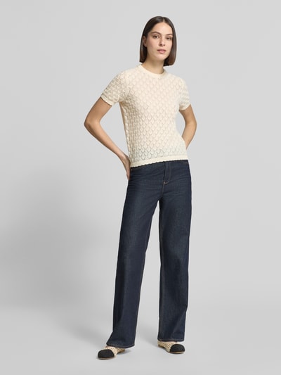 Modelka nosi Strickshirt mit Lochstickerei von Jake*s Collection w kolorze kremowym, bawełniany miks, prosty krój, okrągły dekolt, krótkie rękawy, ażurowa faktura, widok całej sylwetki z przodu.