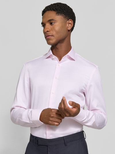 Männermodel trägt Super Slim Fit Businesshemd in Premiumqualität von Jake*s in zartem Rosa, glatte Textur, Nahaufnahme Oberkörper.