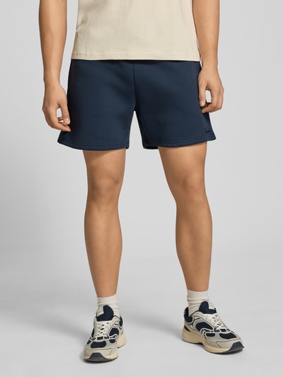 Männermodel trägt Shorts mit Kordelzug und Eingrifftaschen von REVIEW, dunkelblau, Baumwoll-Mix, Gerader-Schnitt, Nahaufnahme Oberkörper bis Knie.